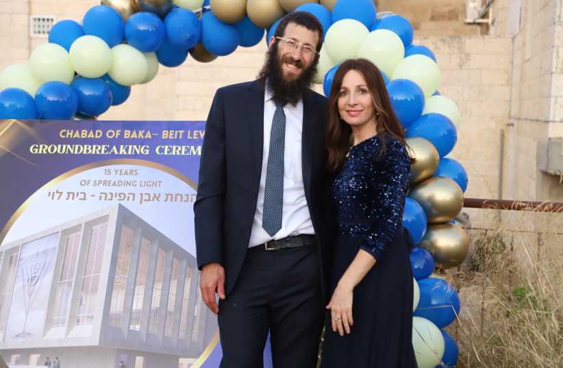  Rabbi Avraham & Nechama Dina Hendel at Chabad of Baka's groundbreaking ceremony, with the projection of the new building behind them. (credit: Esther Hadassah Mizrahi)