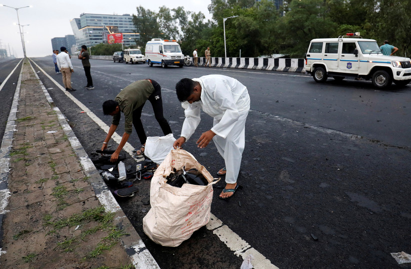 Police officials collect the belongings of the victims at the site of a road accident in Ahmedabad, India, July 20, 2023. (credit: REUTERS/AMIT DAVE)