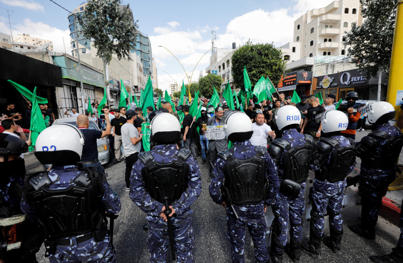 Les forces palestiniennes montent la garde alors que les partisans palestiniens du Hamas participent à un rassemblement anti-israélien contre les tensions dans la mosquée Al-Aqsa de Jérusalem, à Hébron en Cisjordanie, le 14 octobre 2022. (Crédit : MUSSA QAWASMA/REUTERS)