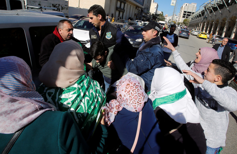  Members of Palestinian security forces detain a protester as they disperse a Hamas demonstration in Hebron in the West Bank December 14, 2018. (credit: MUSSA QAWASMA/REUTERS)