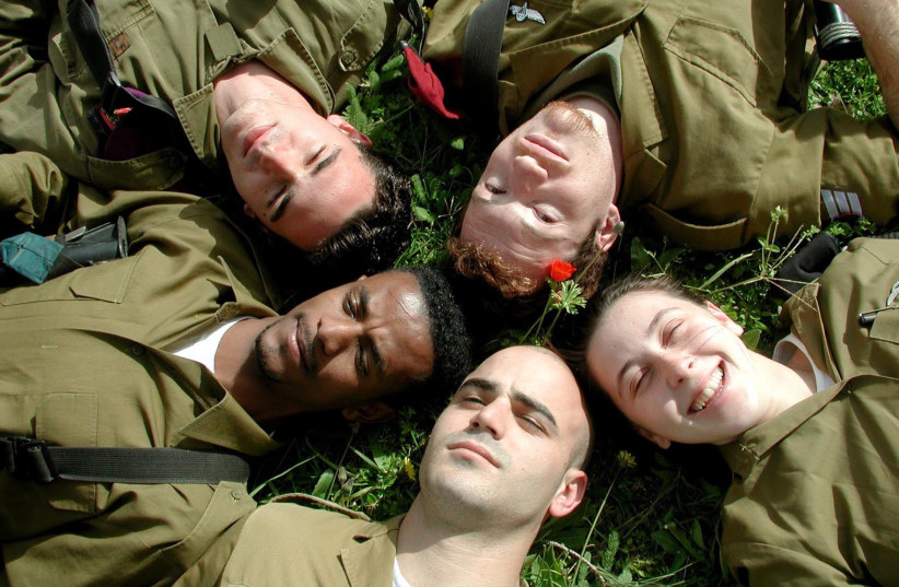  IDF soldiers laying on grass. (credit: Wikimedia Commons)