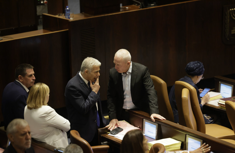  Defense Minister Yoav Gallant speaks to opposition leader Yair Lapid as the Knesset votes on the reasonableness standard bill. (credit: MARC ISRAEL SELLEM)