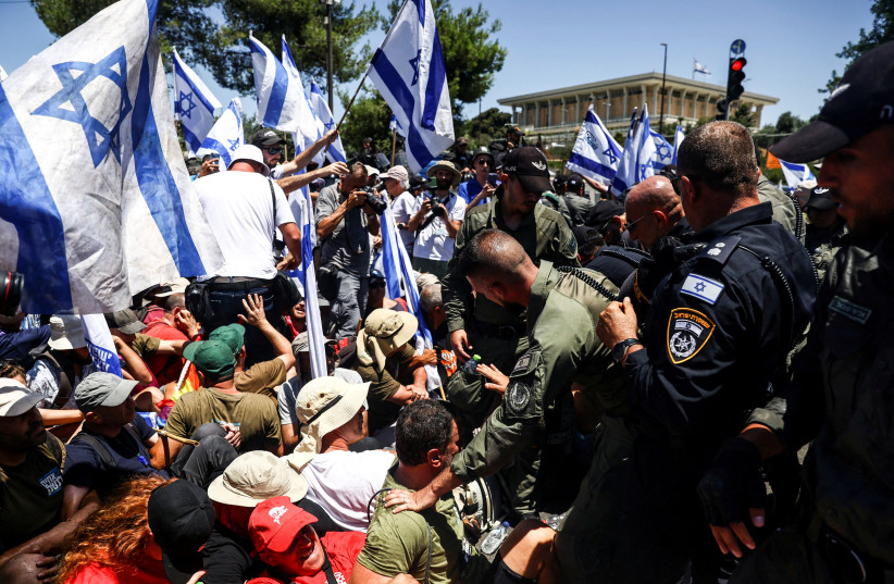  Protesters sit on a street during a demonstration against Israeli Prime Minister Benjamin Netanyahu and his nationalist coalition government's judicial overhaul, near the Knesset, Israel's parliament in Jerusalem July 24, 2023. (credit: REUTERS/Ronen Zvulun)