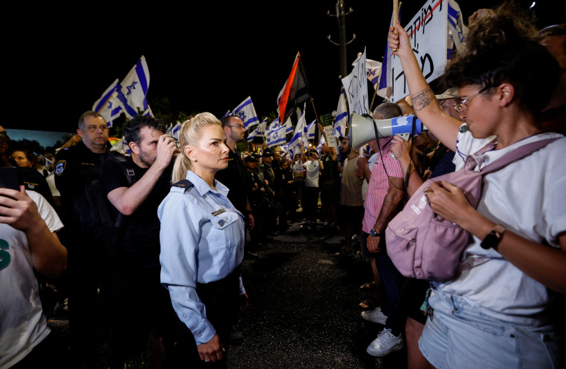  A policewoman stands opposite to a protester during a demonstration, following a parliament vote on a contested bill that limits Supreme Court powers to void some government decisions, near the Knesset, Israel's parliament in Jerusalem July 24, 2023 (credit: AMIR COHEN/REUTERS)