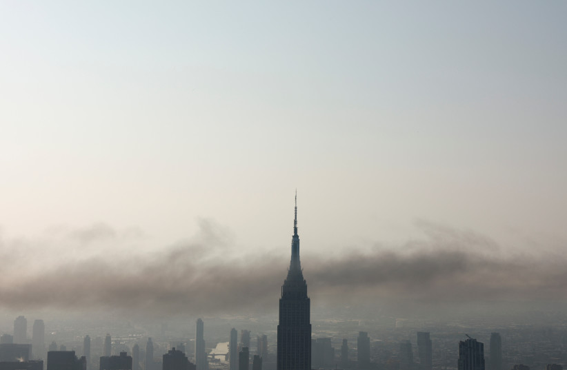 Smoke passes around the Empire State Building after a construction crane caught fire on a high-rise building in Manhattan, New York City, U.S., July 26, 2023 (credit: Amr Alfiky/Reuters)
