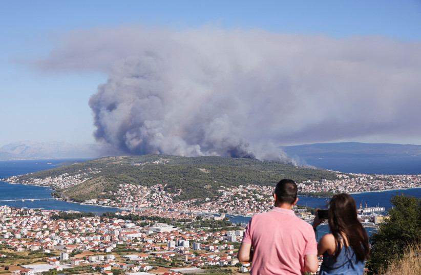 People watch the wildfire on the island Ciovo, from Seget Gornji, Croatia, July 27, 2023. (credit: ANTONIO BRONIC/REUTERS)