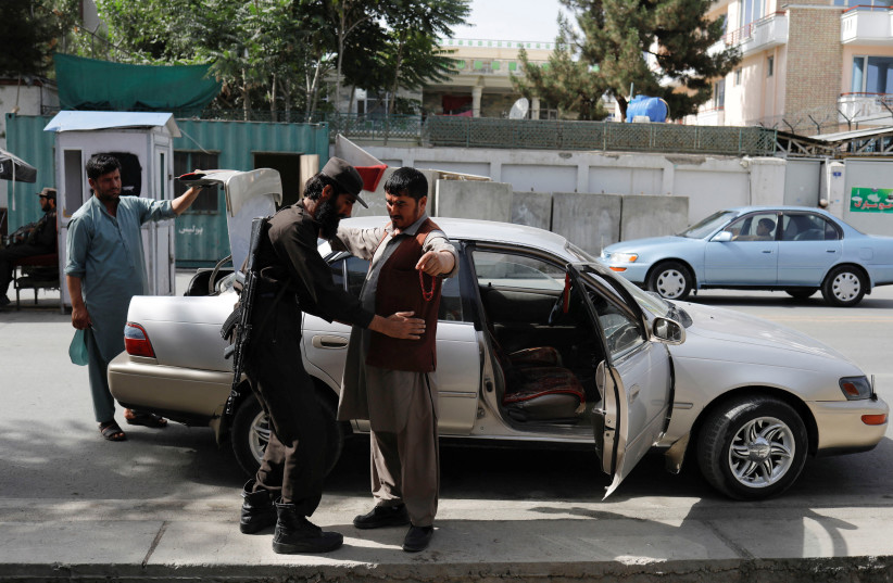  A Taliban soldier checks a man at a checkpoint in Kabul, Afghanistan, July 6, 2023. (credit:  REUTERS/ALI KHARA)