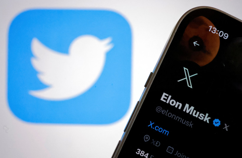  The new logo of Twitter is seen on Elon Musk’s Twitter account on an iPhone as the old Twitter logo is displayed on a MacBook screen in Galway, Ireland July 24, 2023 (credit: REUTERS/CLODAGH KILCOYNE)