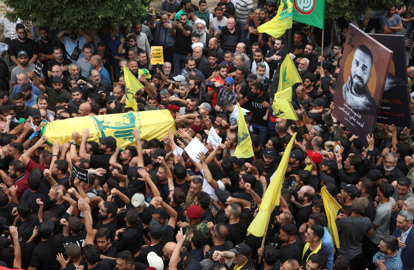  Supporters of Lebanon's Hezbollah carry the coffin of Ahmed Qassas, who died during exchange of fire at the area where a truck was overturned the previous night in the town of Kahaleh, during his funeral, in Beirut suburbs, Lebanon August 10, 2023. (credit: MOHAMED AZAKIR/REUTERS)