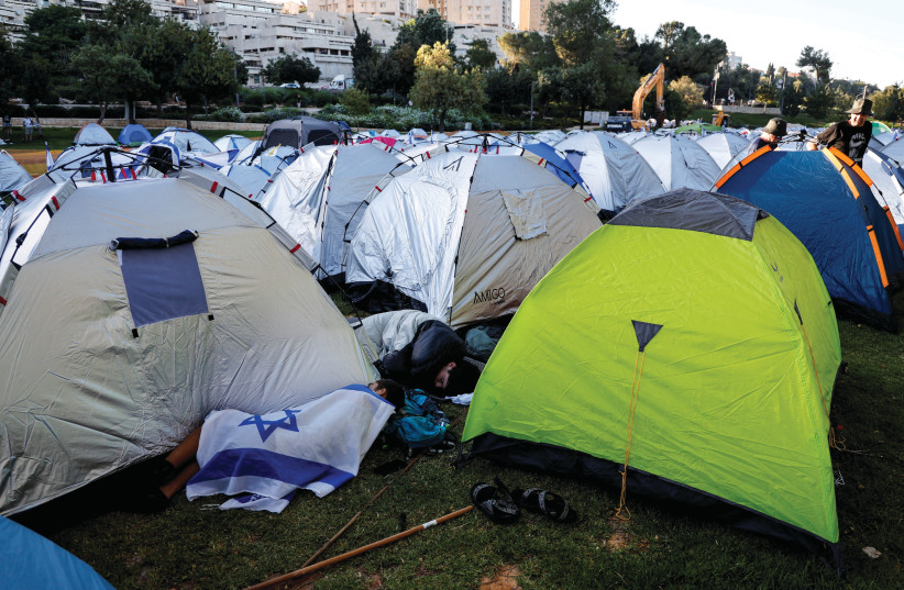  Protesters sleep in tents and on the grass near the Knesset, in Jerusalem, July 24. (credit: AMMAR AWAD/REUTERS)