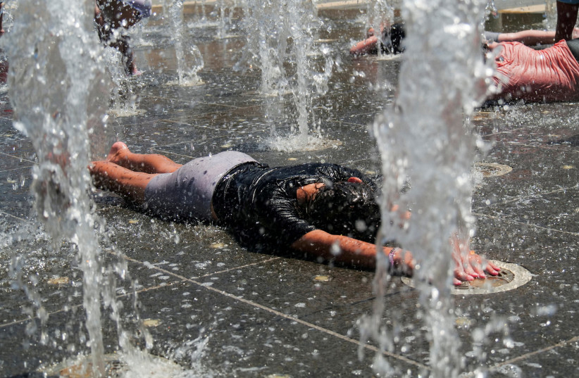  Children play in a water fountain during a heatwave, near the walls of Jerusalem's Old City, July 13, 2023. (credit: REUTERS/DEDI HAYUN)