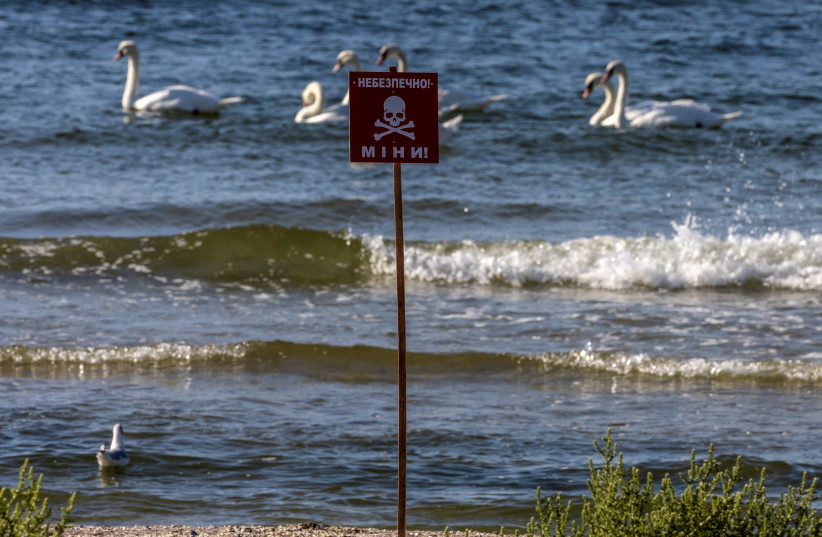  A sign reads ''Danger! Mines!'' at a beach as swans enjoy the waters of the Black Sea, amid Russia's invasion of Ukraine, in Koblevo near Mykolaiv, Ukraine, September 2, 2022 (credit: UMIT BEKTAS/REUTERS)