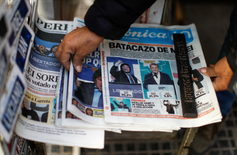 Une personne prend un journal annonçant la victoire du candidat présidentiel Javier Milei aux primaires argentines un jour après les élections, à Buenos Aires, Argentine le 14 août 2023 (crédit : AGUSTIN MARCARIAN/REUTERS)