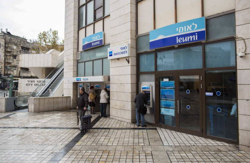 Israelis walks next to Bank Leumi in Jerusalem. (credit: YONATAN SINDEL/FLASH90)