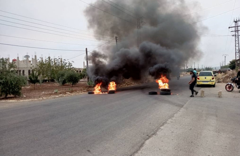 Tires burn as demonstrators protest against the Syrian government decision on increasing the prices of fuels in Sweida, Syria, August 17,2023. (credit: Sweida 24/Handout via REUTERS)