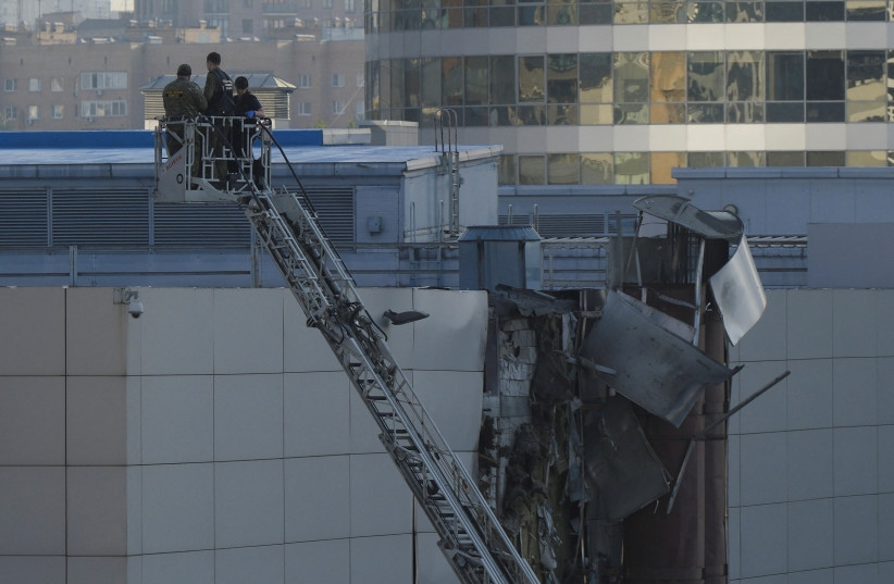 Investigators work near a damaged roof following a reported Ukrainian drone shot down in Moscow, Russia, August 18, 2023