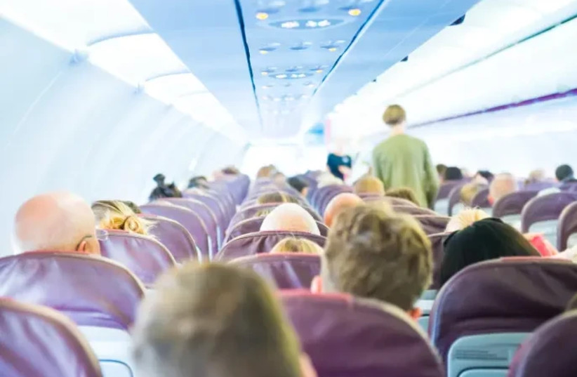  Passengers on an airplane are seated in rows. (credit: MAARIV)
