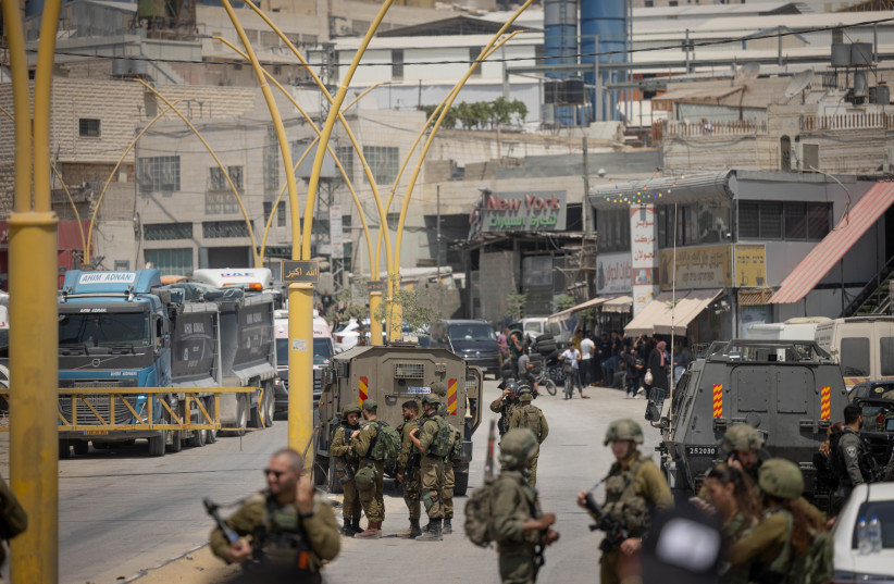  Israeli security forces seen at the entrance to the West Bank city of Hebron, after the deadly shooting attack on Route 60, August 21, 2023. (credit: CHAIM GOLDBEG/FLASH90)