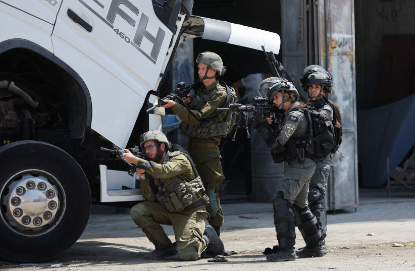  Israeli troops stand guard, near the scene of a shooting, near Hebron, in the West Bank August 21, 2023. (credit: MUSSA QAWASMA/REUTERS)