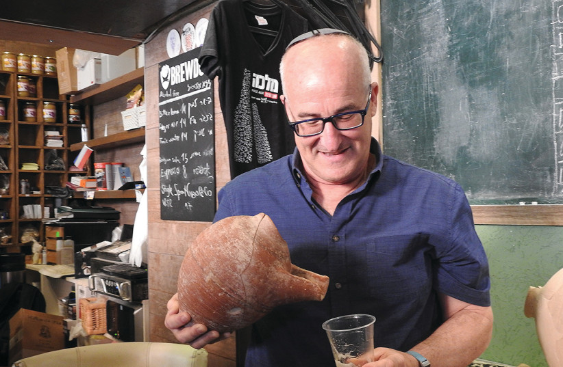  PROF. AREN MAEIR of Bar-Ilan University’s Department of Land of Israel Studies and Archaeology demonstrates how beer was poured from an ancient Philistine beer jug.   (credit: MIKE HORTON)