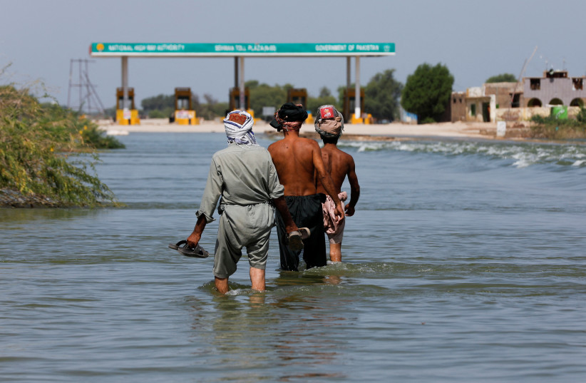  Displaced people walk on flooded highway, following rains and floods during the monsoon season in Sehwan, Pakistan, September 16, 2022. (credit: Akhtar Soomro/Reuters)