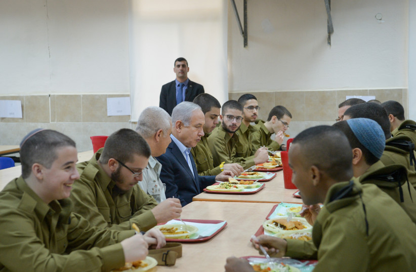  Prime Minister Benjamin Netanyahu eats with newly recruited Israeli soldiers during his visit at the Tel Hashomer army base on November 26, 2018 (credit: AVI DISHI/FLASH90)