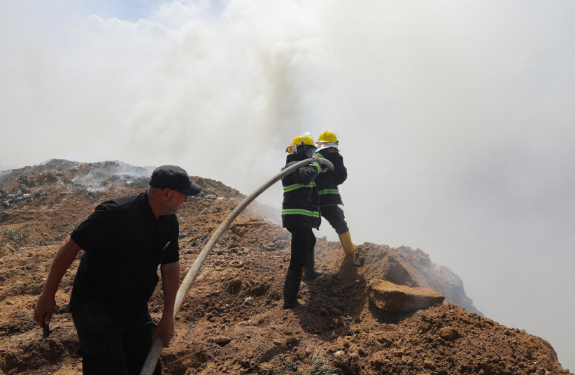  Palestinian firemen extinguish a fire at a landfill in Juhr al-Deek, southeast of Gaza City, September 3, 2023.  (credit: Reuters/Arafat Barbakh)