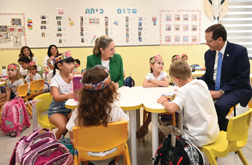  PRESIDENT ISAAC HERZOG and his wife, Michal, interact with first graders in Yokne’am. (credit: HAIM ZACH/GPO)