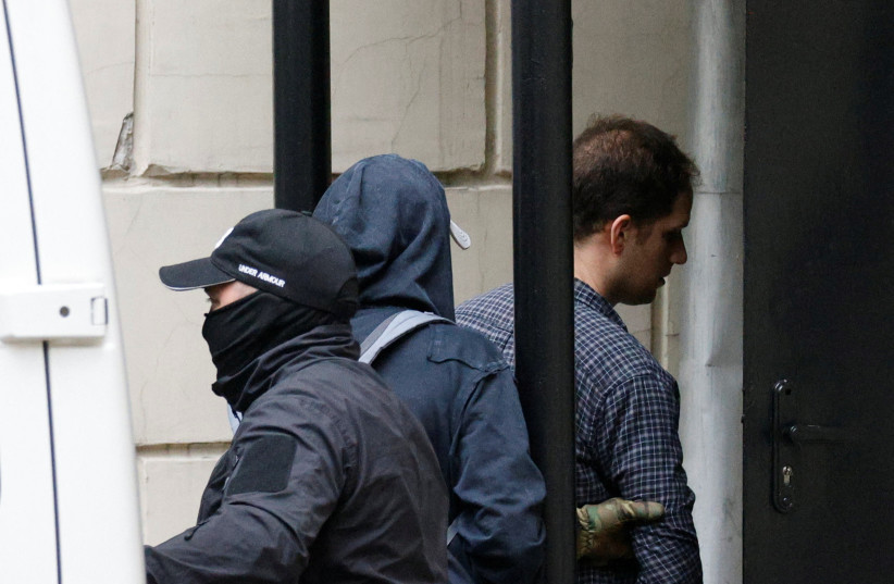 Wall Street Journal reporter Evan Gershkovich, who was arrested in March while on a reporting trip and accused of espionage, is escorted into a court building before a hearing on extending his pre-trial detention, in Moscow, Russia August 24, 2023. (credit: REUTERS/MAXIM SHEMETOV)