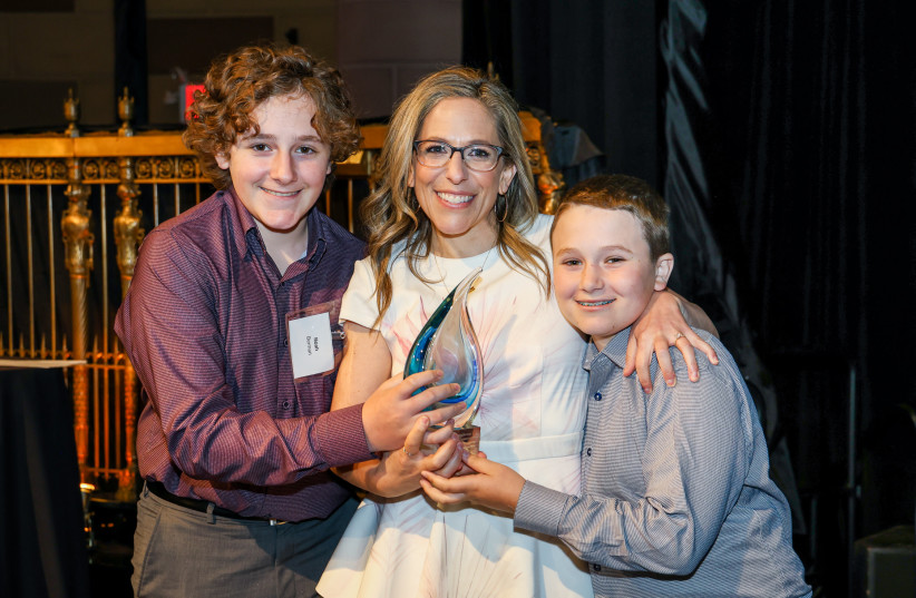  National Women’s Soccer League Commissioner Jessica Berman holds the David J. Stern Leadership Award with her children, Noah, left, and Andrew, right.  (credit: MICHAEL PRIEST PHOTOGRAPHY)