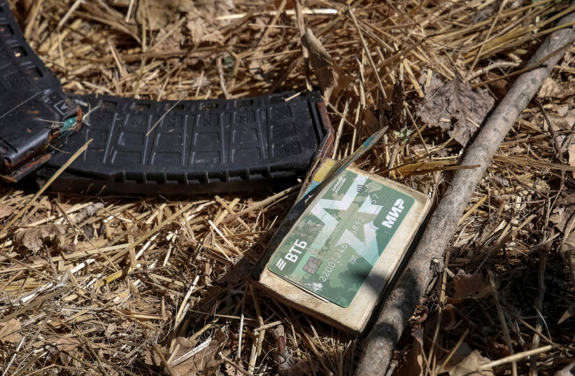   Assault rifle magazines with cartridges and a bank card with the inscription ''Russian Army, World'' are seen near a body of a dead Russian soldier, amid Russia's attack on Ukraine, in the village of Blahodatne in Donetsk Region Ukraine September 8, 2023. (credit: REUTERS/OLEKSANDR RATUSHNIAK)