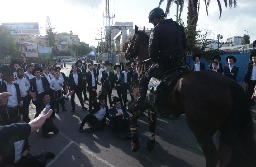  Haredi protesters are seen standing off with an Israel Police officer and horse, on September 13, 2023. (credit: AVSHALOM SASSONI/MAARIV)