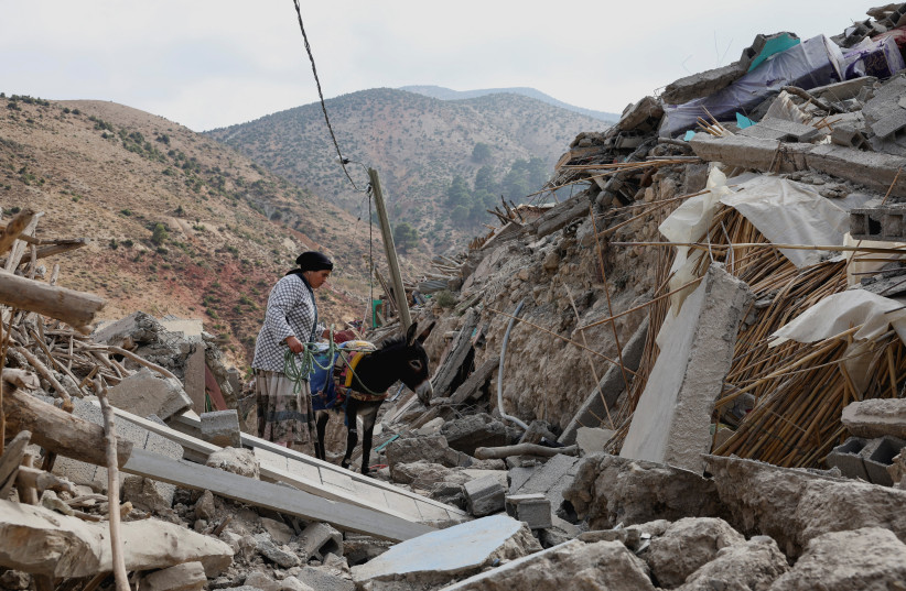  Fatima Belkas stands next to a donkey surrounded by her devastated town days after the deadly earthquake, in Adouz, Morocco September 12, 2023. (credit: REUTERS/EMILIE MADI)