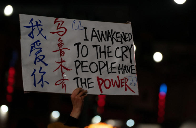 A person holds up a placard while taking part in anti-Chinese government protests, amid China's ''zero-COVID'' policy, near the Chinese consulate in New York City, U.S., November 29, 2022.  (credit: David ‘Dee’ Delgado/Reuters)