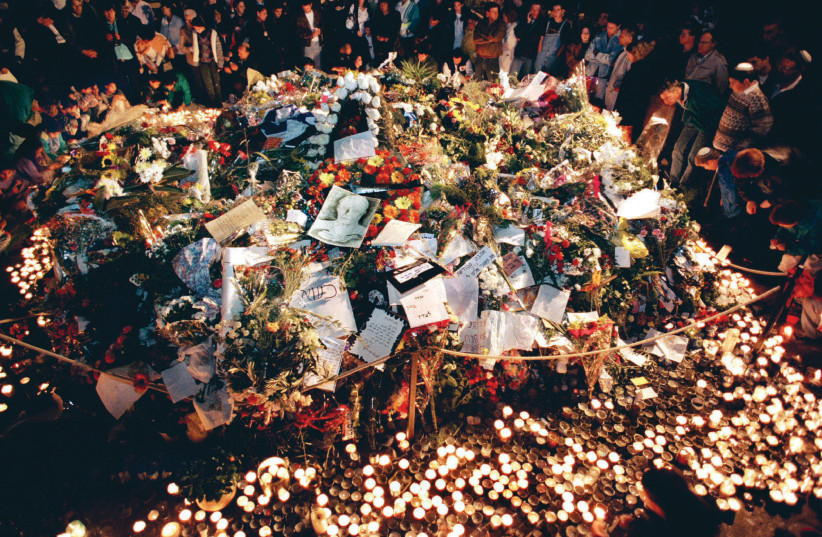  Grave of the assassinated Rabin covered in bouquets, drawings and poems, surrounded by thousands of burning memorial candles, Nov. 11, 1995.  (credit: JIM HOLLANDER/REUTERS)