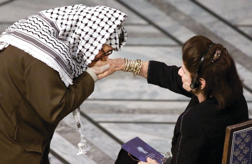  ARAFAT KISSEs Leah Rabin’s hand, at a Rabin memorial in Oslo’s City Hall, Nov. 2, 1999.  (credit: REUTERS)