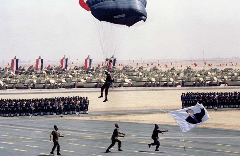  An Egyptian special forces member lands on parade ground with a banner of president Hosni Mubarak, during a 25-anniversary ceremony, in Egypt’s Eastern desert on Oct. 6, 1998.  (credit: MONA SHARAF/REUTERS)