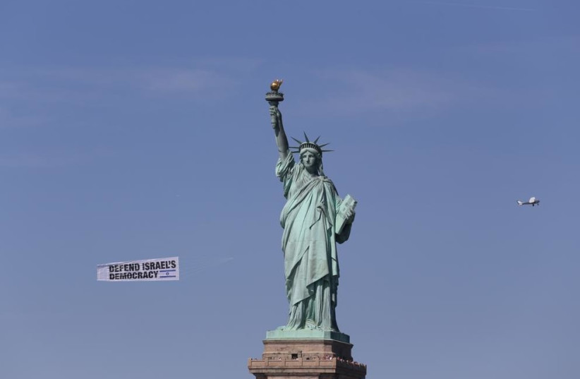  Banners flying against Israel's judicial reform fly past the Statue of Liberty. (credit: ROI BOSHI)