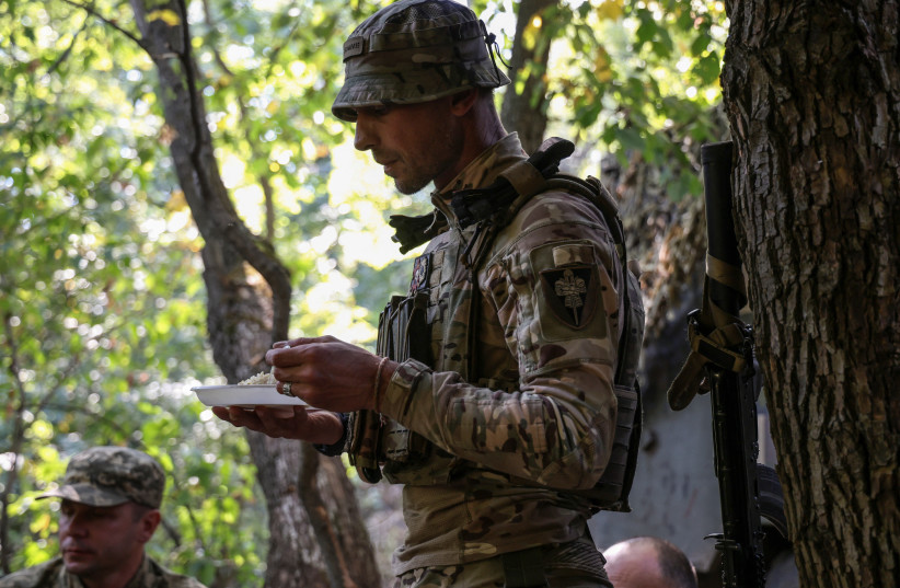  A Ukrainian serviceman eats, at a position in a front line near the town of Bakhmut, amid Russia's attack on Ukraine, in Donetsk region, Ukraine September 19, 2023. (credit: REUTERS/OLEKSANDR RATUSHNIAK)