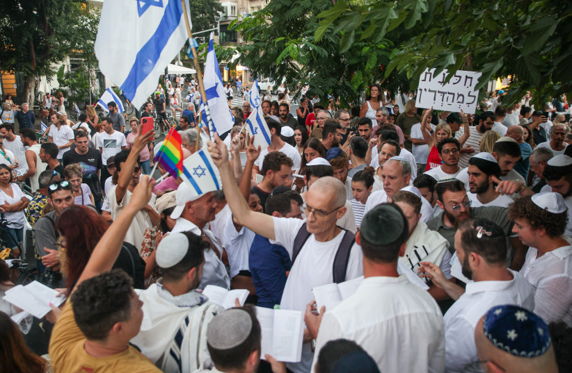  Jews pray while activists protest against gender segregation in the public space during a public prayer on Dizengoff Square in Tel Aviv, on Yom Kippur, the Day of Atonement, and the holiest of Jewish holidays, September 25, 2023. (credit: ITAI RON/FLASH90)