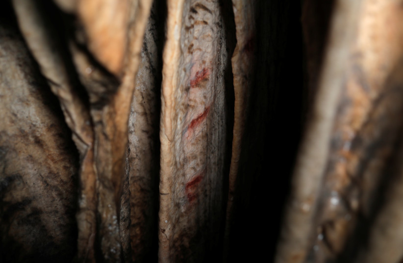 Red ocher markings which were painted on stalagmites by Neanderthals about 65,000 years ago, according to an international study, are seen in a prehistoric cave in Ardales, southern Spain, August 7, 2021. (credit: REUTERS/JON NAZCA)