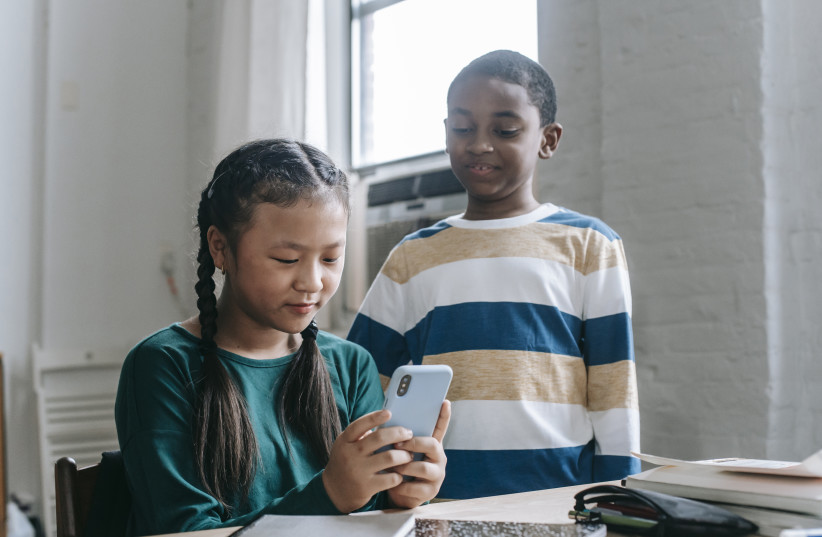  Children watching something on a smartphone (credit: PEXELS)