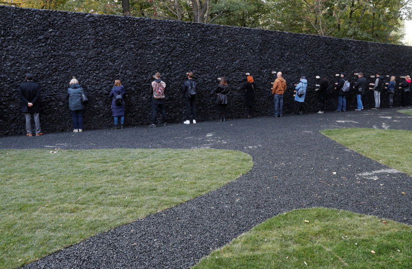  People take part in a performance by artist Marina Abramovic next to her artwork ''Crystal Wall of Crying'' at Babyn Yar, the site of one of the biggest massacres of the Holocaust during World War Two, in Kyiv, Ukraine October 4, 2021. Picture taken October 4, 2021. (credit: REUTERS/GLEB GARANICH)