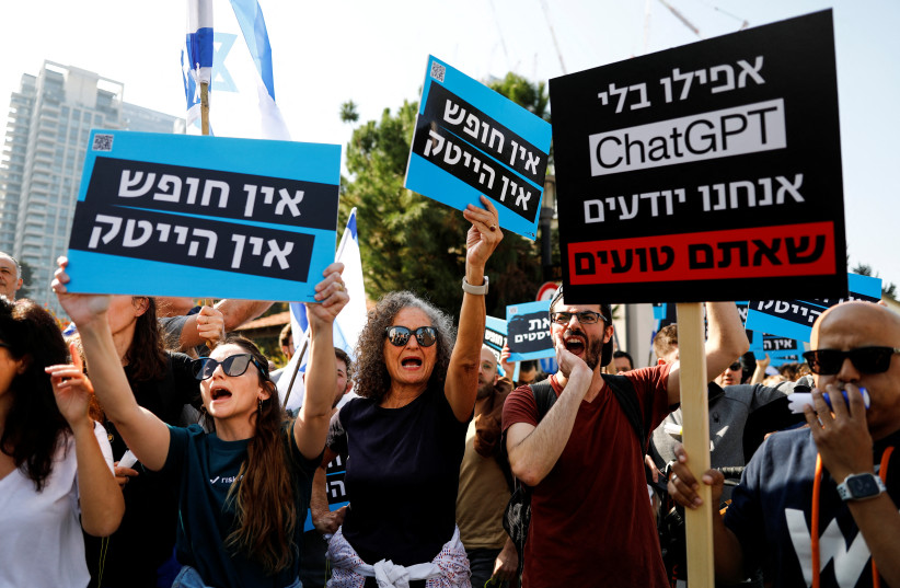  Israelis working in the hi-tech sector hold signs with the Hebrew words ''No democracy, no hi-tech'' and ''Even without ChatGPT we know that you're wrong'' as they demonstrate against proposed judicial reforms by Israel's new right-wing government in Tel Aviv, Israel January 24, 2023. (credit: REUTERS/CORINNA KERN)