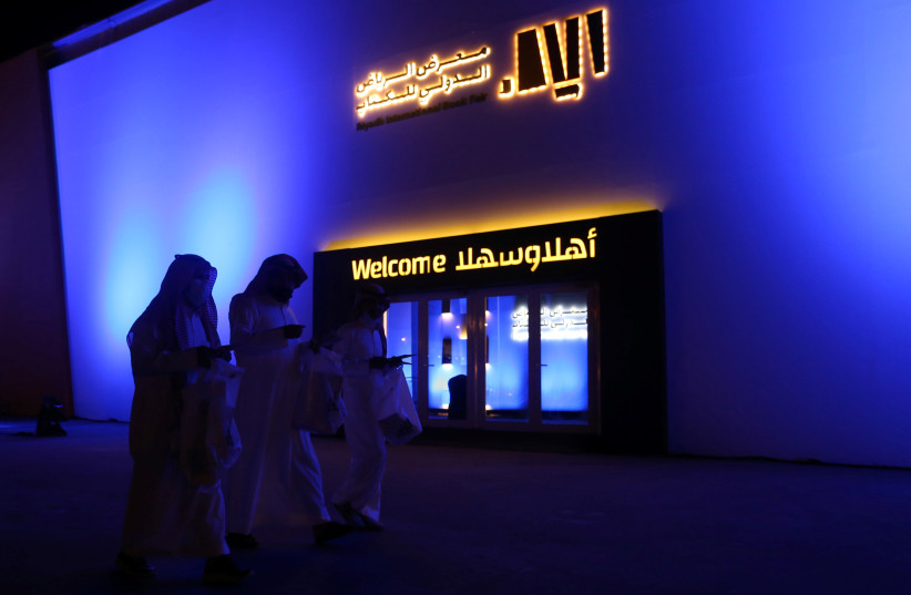  Saudi men walk out after buying some books at the Riyadh International Book Fair in Riyadh, Saudi Arabia, October 2, 2021. (credit: Ahmed Yosri/Reuters)