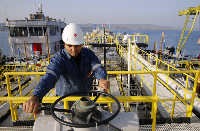 A worker checks the valve gears of pipes linked to oil tanks at Turkey's Mediterranean port of Ceyhan, which is run by state-owned Petroleum Pipeline Corporation (BOTAS), some 70 km (43.5 miles) from Adana February 19, 2014 (credit: REUTERS/UMIT BEKTAS)