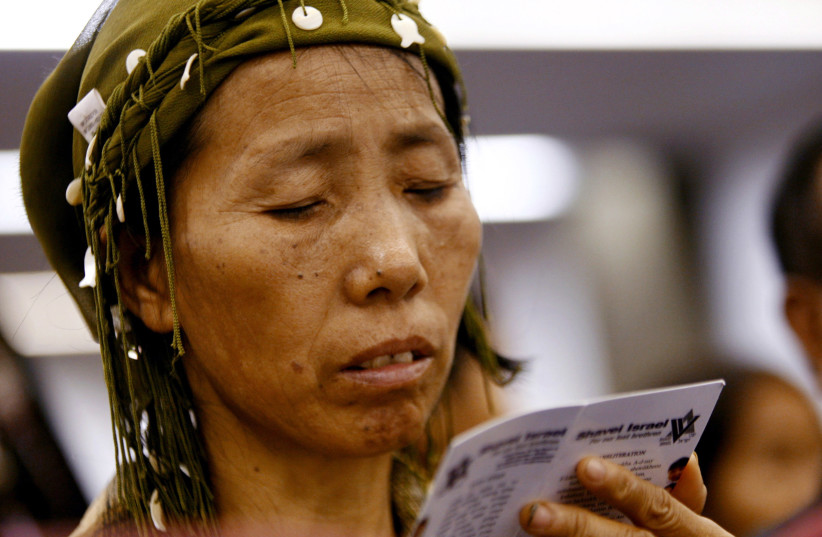  A newly arrived Jewish immigrant from India recites a prayer upon arrival at Ben Gurion international airport near Tel Aviv November 21, 2006. (credit: REUTERS/GIL COHEN MAGEN)