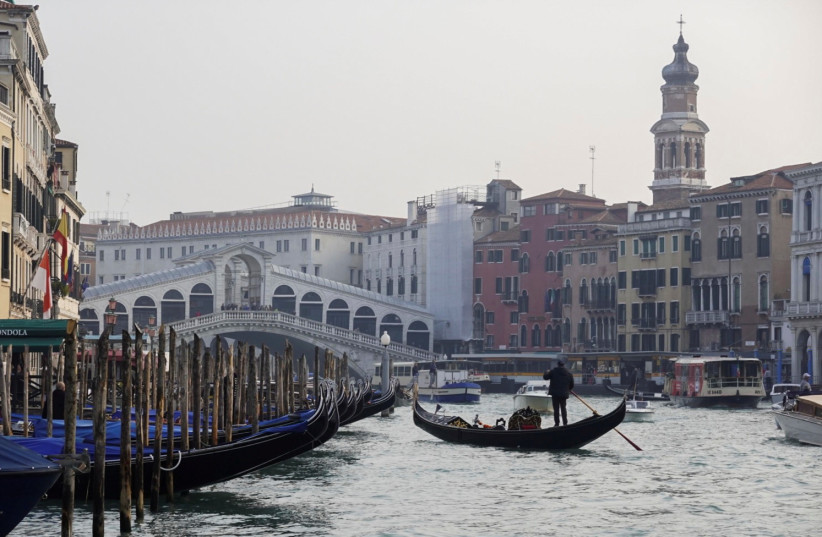  A gondola is pictured on Grand Canal in front of Rialto bridge in Venice, Italy, October 20, 2021 (credit: REUTERS/FABRIZIO BENSCH)