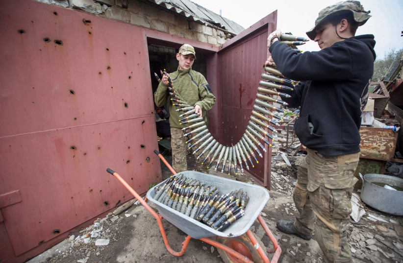  Ukrainian servicemen load ammunition for a machine gun at their position at a front line, amid Russia's attack on Ukraine, in Donetsk region, Ukraine May 5, 2023. (credit: REUTERS)