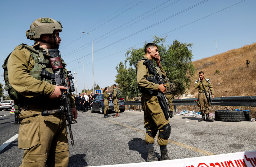  Israeli soldiers attend the scene at which, according to Israeli police, a truck driver hit several pedestrians before being neutralised at Maccabim checkpoint in the West Bank August 31, 2023. (credit: REUTERS/AMMAR AWAD)